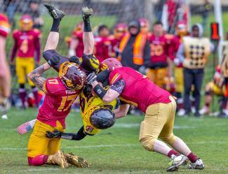 photo of three men playing football by John Torcasio courtesy of Unsplash.