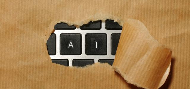 A piece of cardboard with a keyboard appearing through it by Immo Wegmann courtesy of Unsplash.